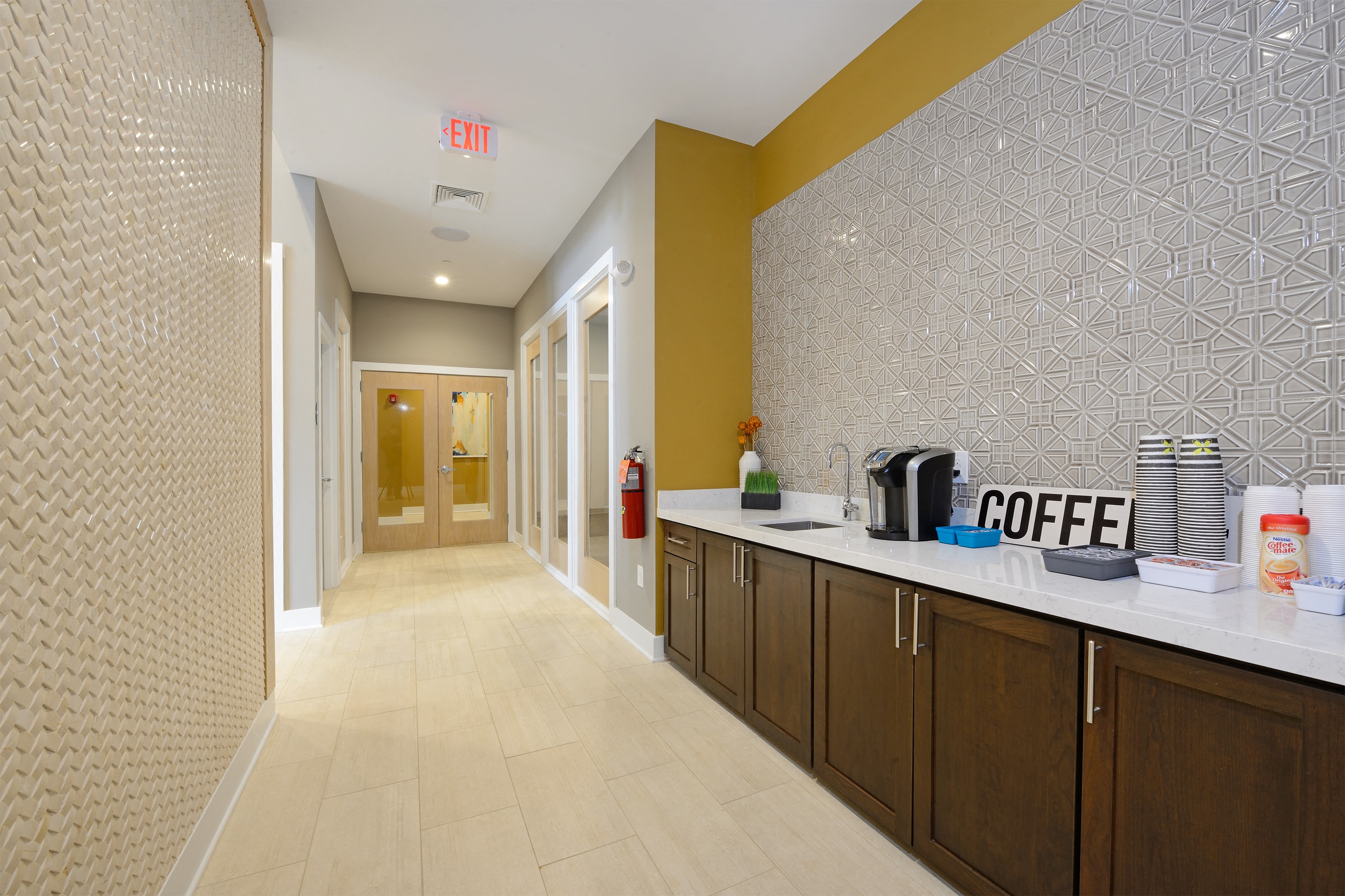 the lobby of a coffee shop with a counter and a hallway with a door