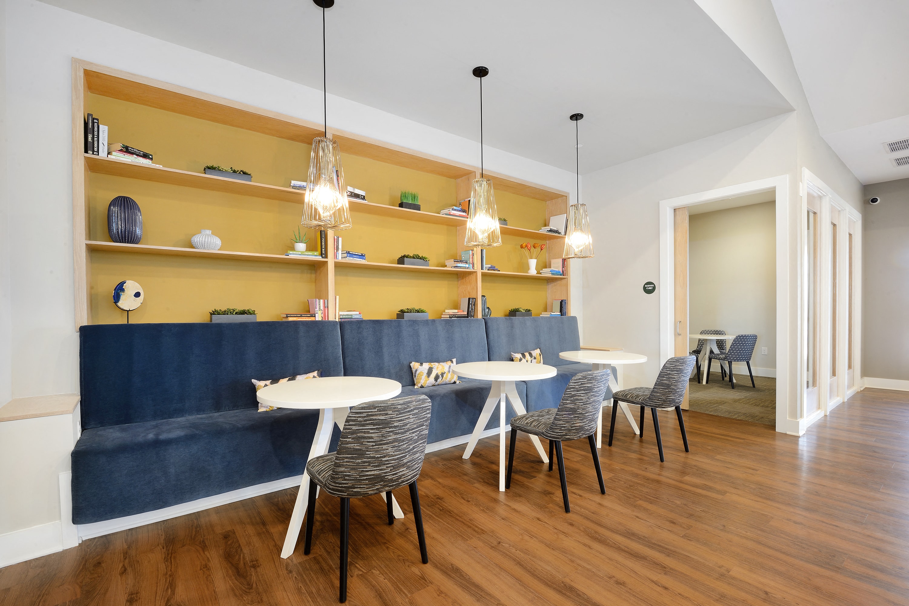 a dining room with tables and chairs and a blue couch