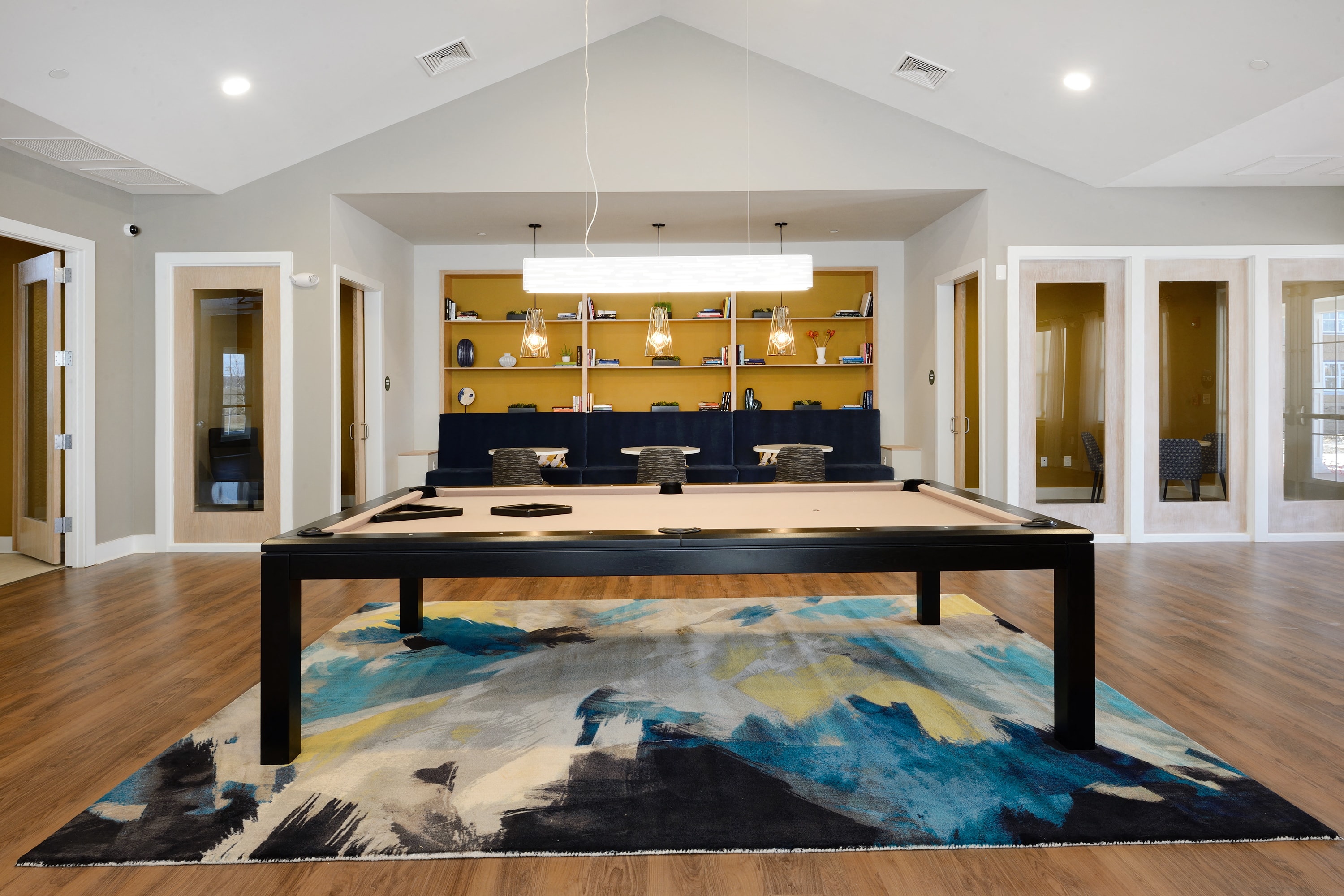 a pool table in a living room with a large rug