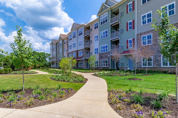an exterior view of an apartment building with a sidewalk