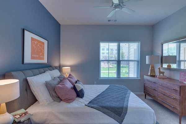 a bedroom with a large bed and a ceiling fan