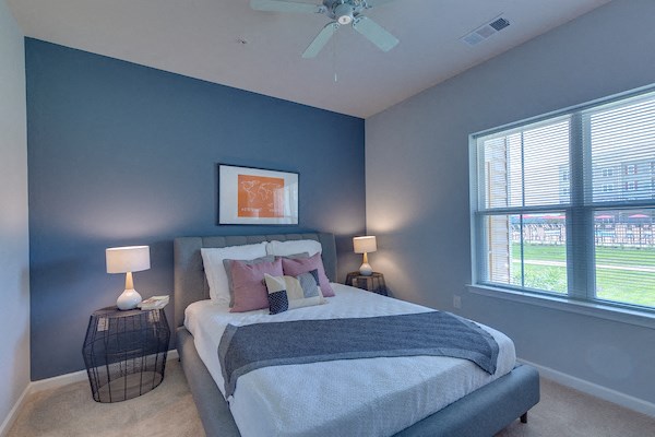 a bedroom with a large bed and a ceiling fan