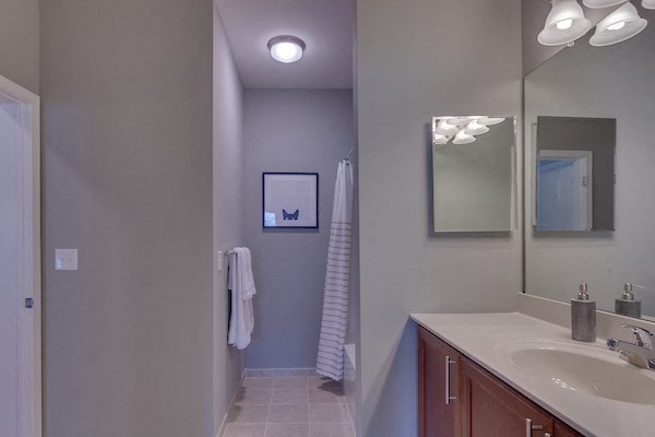 a bathroom with a sink and a mirror and a shower