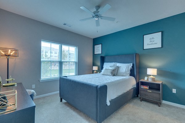 a bedroom with a bed and a ceiling fan