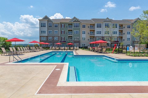 a swimming pool with an apartment building in the background
