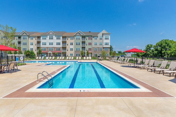 a swimming pool with an apartment building in the background