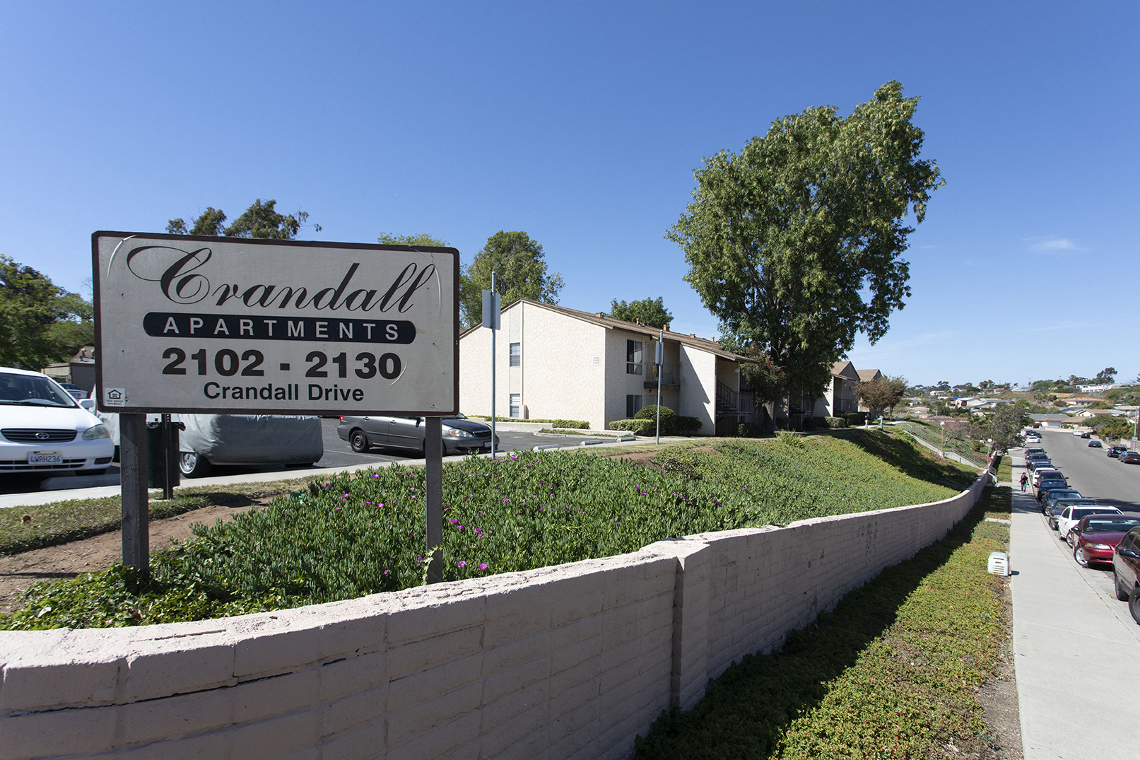 a sign for coronado apartments in front of a parking lot
