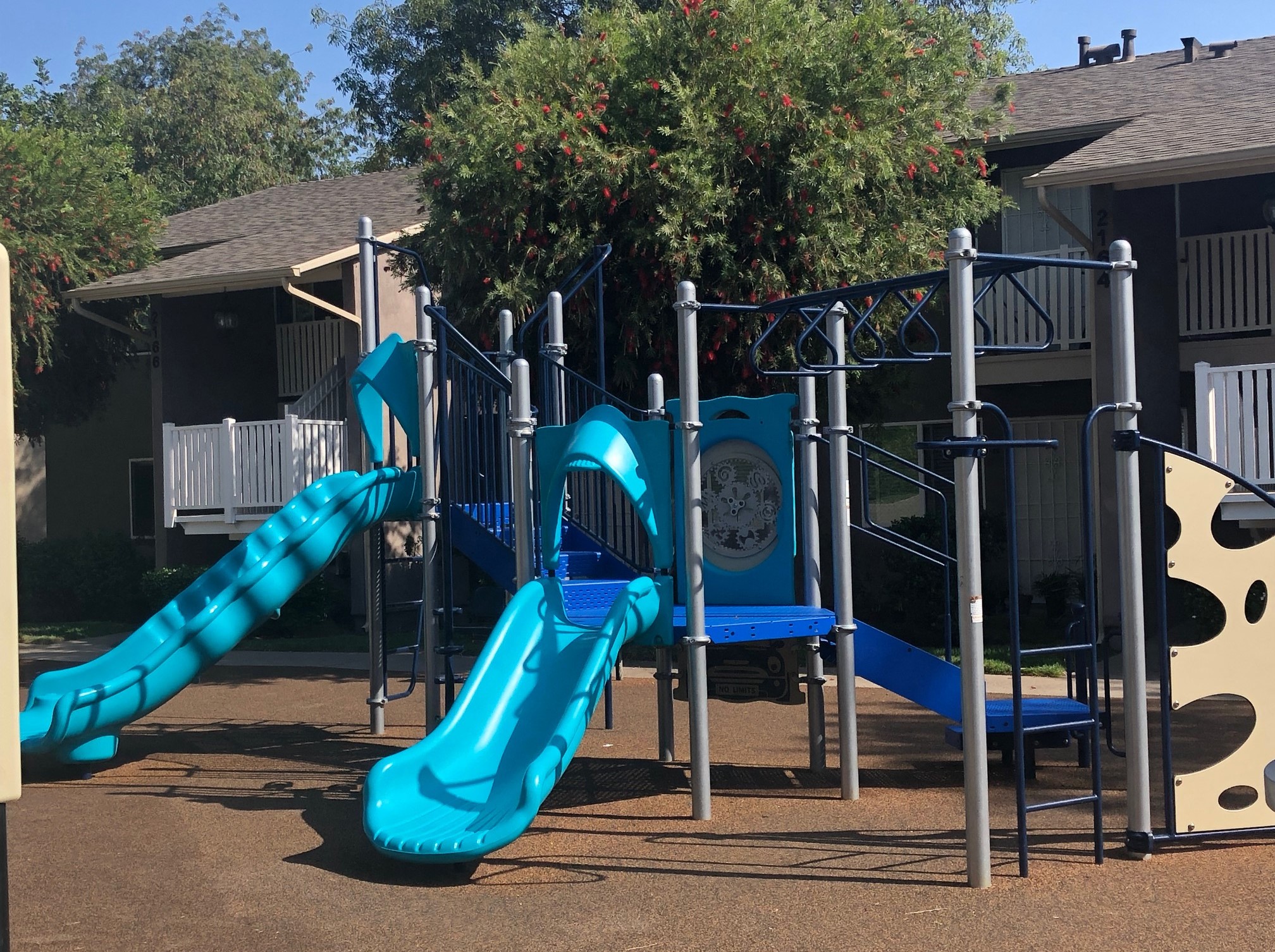 a playground with two slides and a swing set