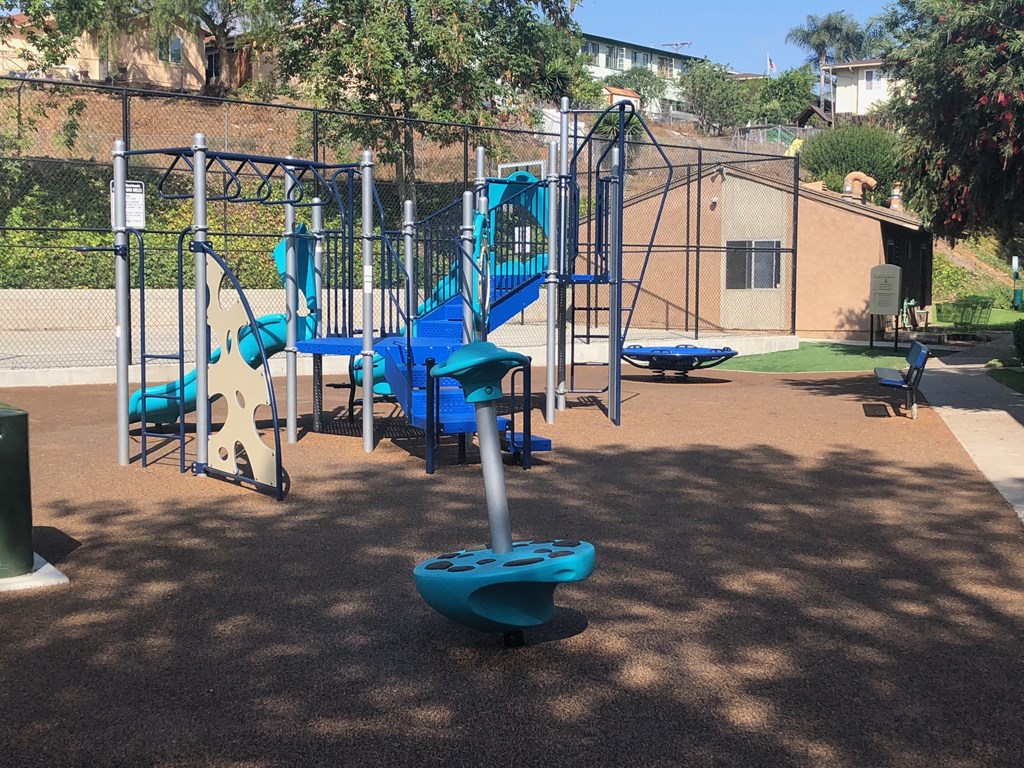 a playground at a park with a blue swing set
