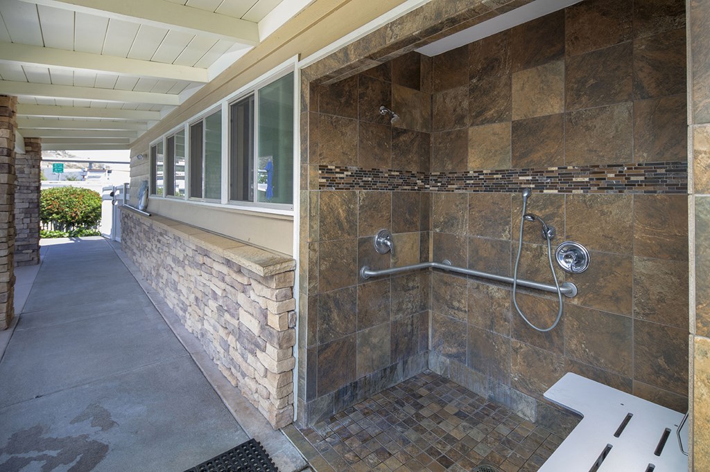 a bathroom with a shower and a bench