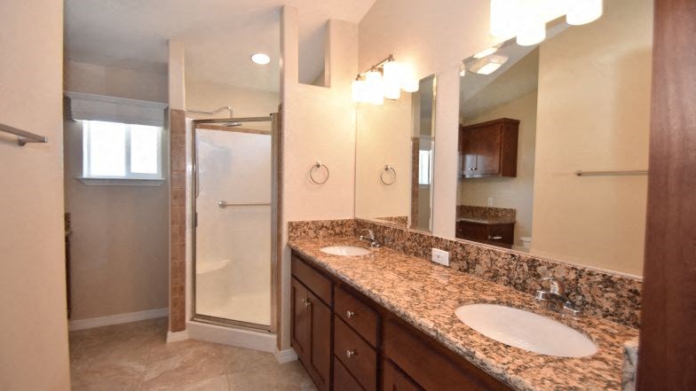 a bathroom with two sinks and a shower