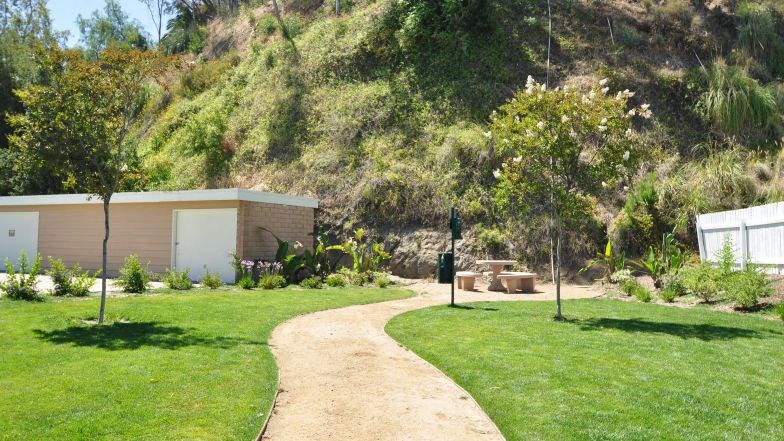 a dirt path leading to a house in the grass