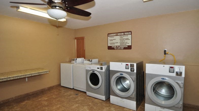 a laundry room with four washing machines and a ceiling fan