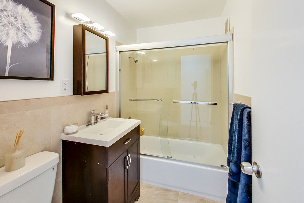 a bathroom with a shower and a sink and a mirror