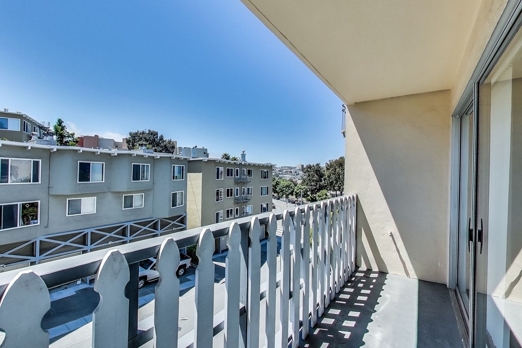 a balcony with a view of buildings and a blue sky