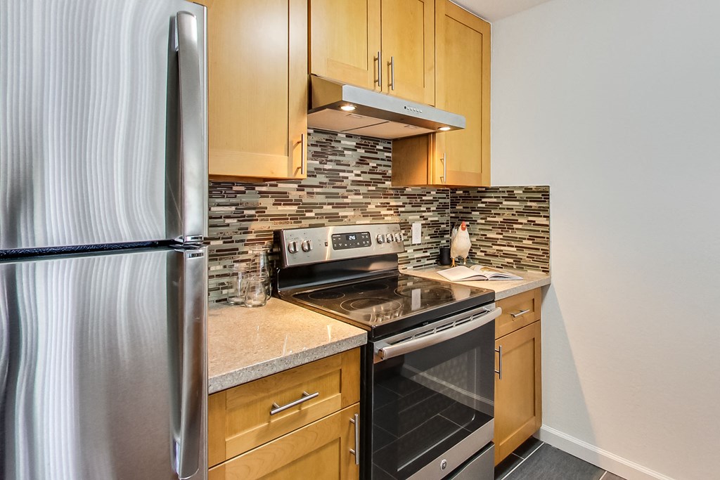 an updated kitchen with stainless steel appliances and wood cabinets