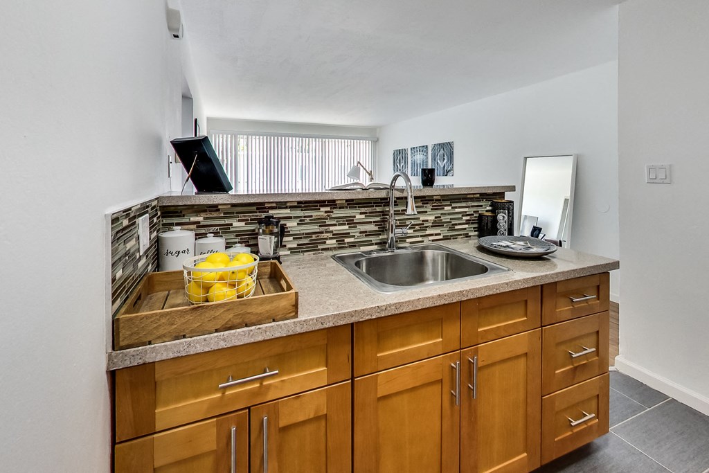 a kitchen with wooden cabinets and a stainless steel sink