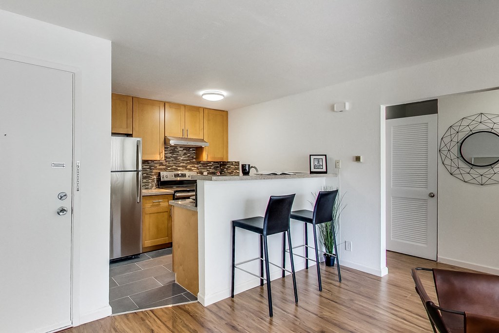 a kitchen with a bar with three stools