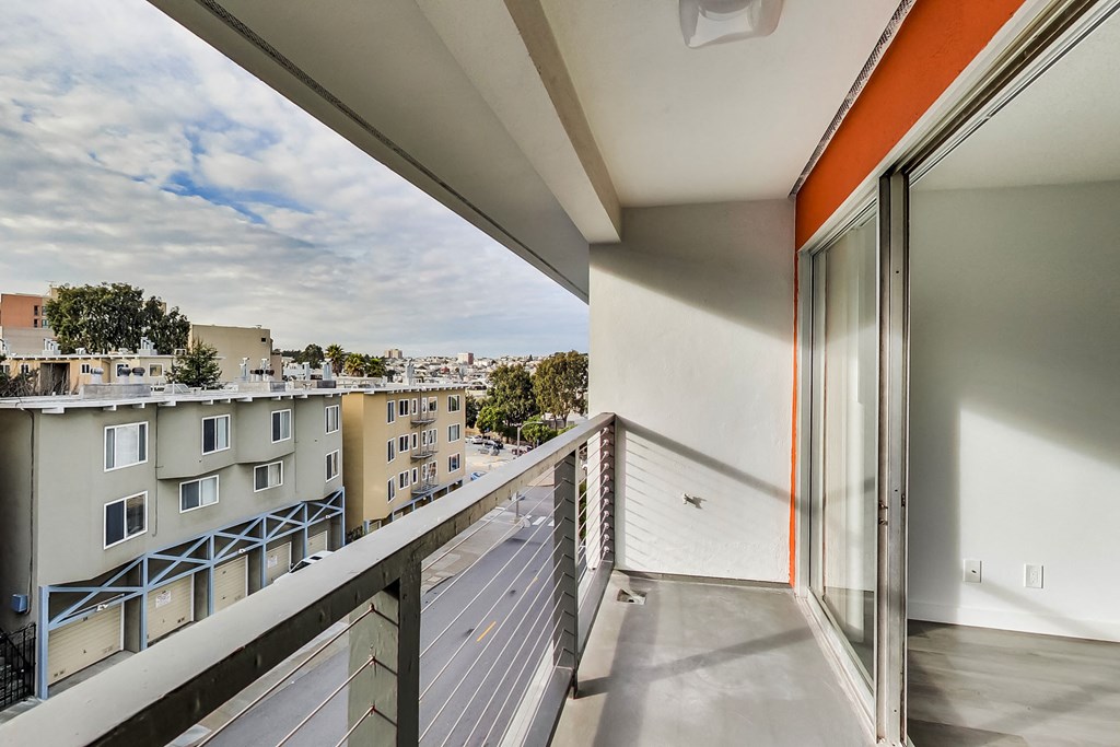 a view of the city from a balcony with a glass door