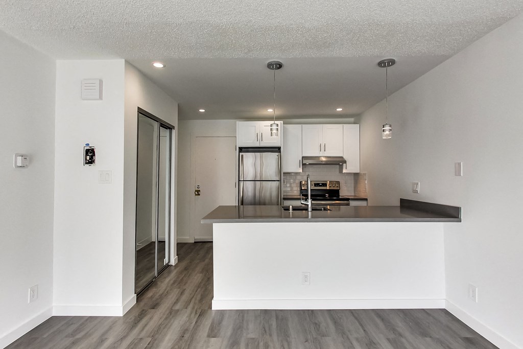 an open kitchen and living room with a large counter top