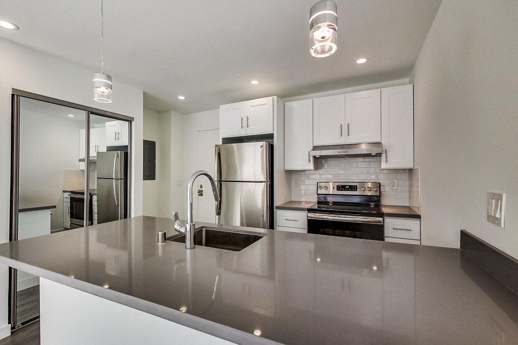 a kitchen with white cabinets and stainless steel appliances