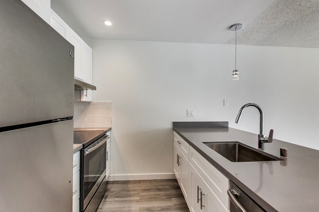 a kitchen with white cabinets and stainless steel appliances