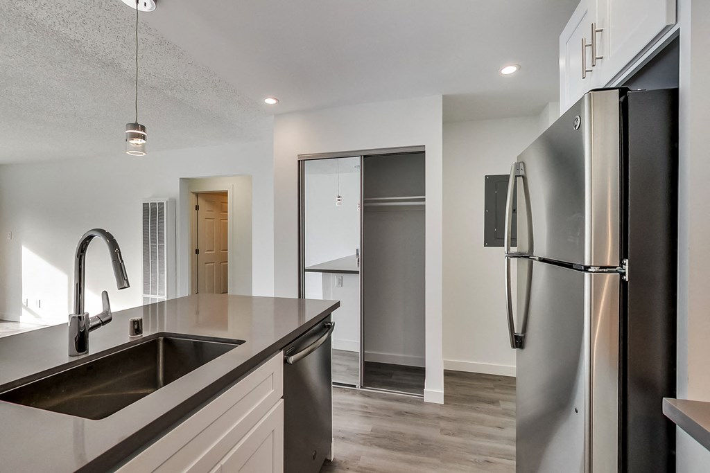 a renovated kitchen with a stainless steel refrigerator and sink