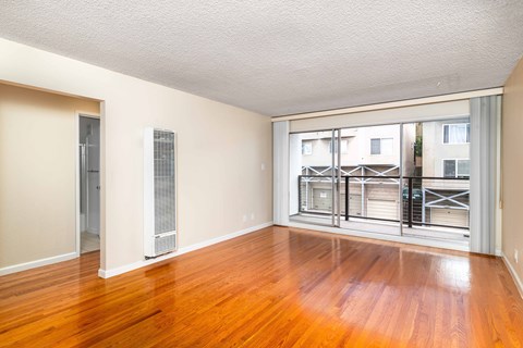 A room with wooden floors and a large window.