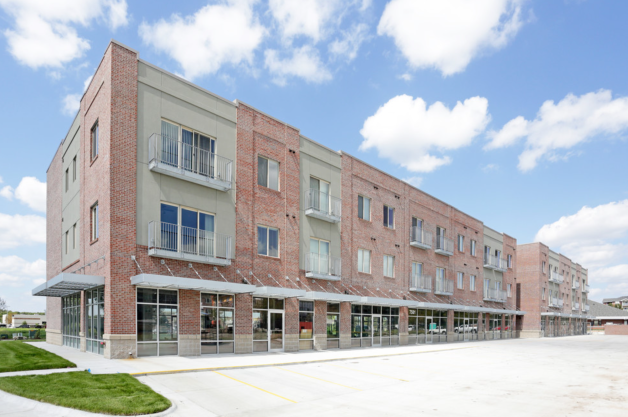 a large brick building with a sidewalk in front of it