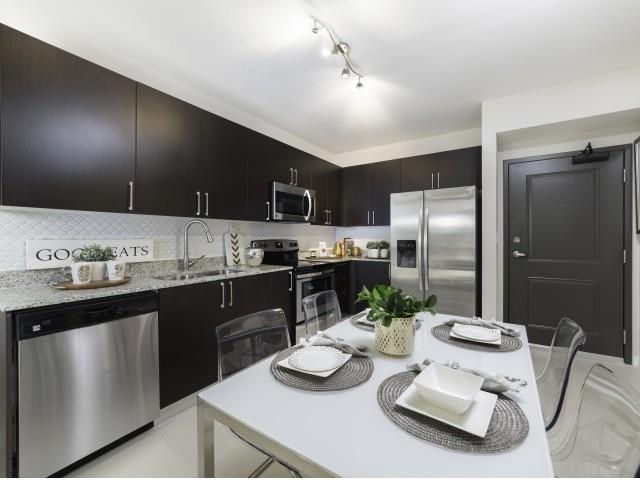 a kitchen with stainless steel appliances and a white table