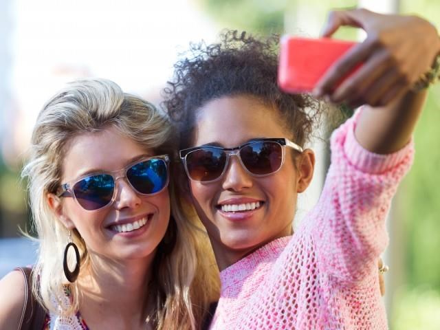two women taking a picture of themselves with a cell phone