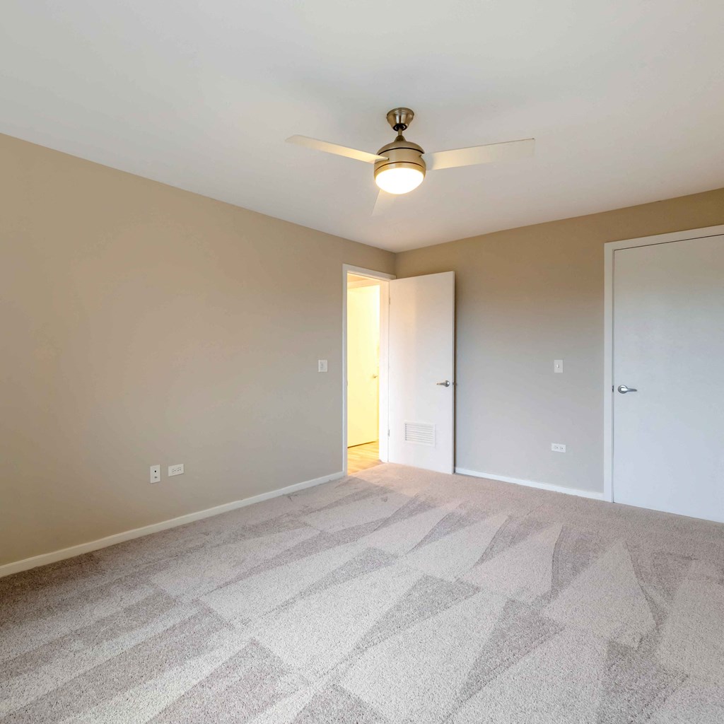 an empty living room with a ceiling fan