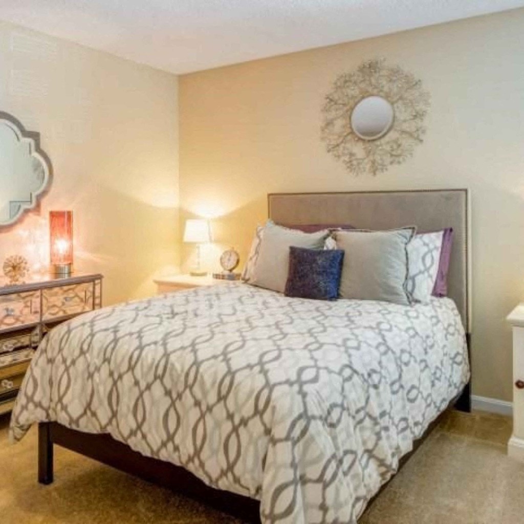 a bedroom with a bed and a mirror on the wall