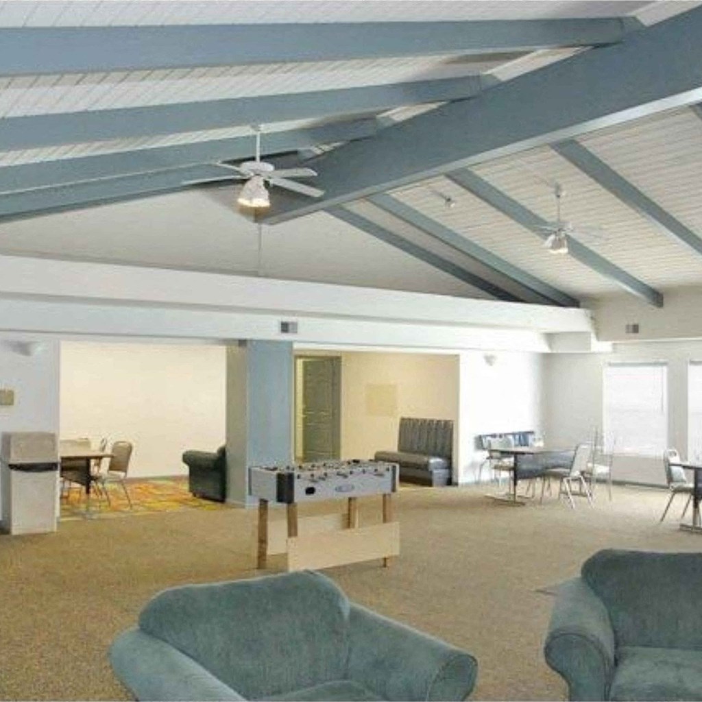 a living room with a ceiling fan and a table