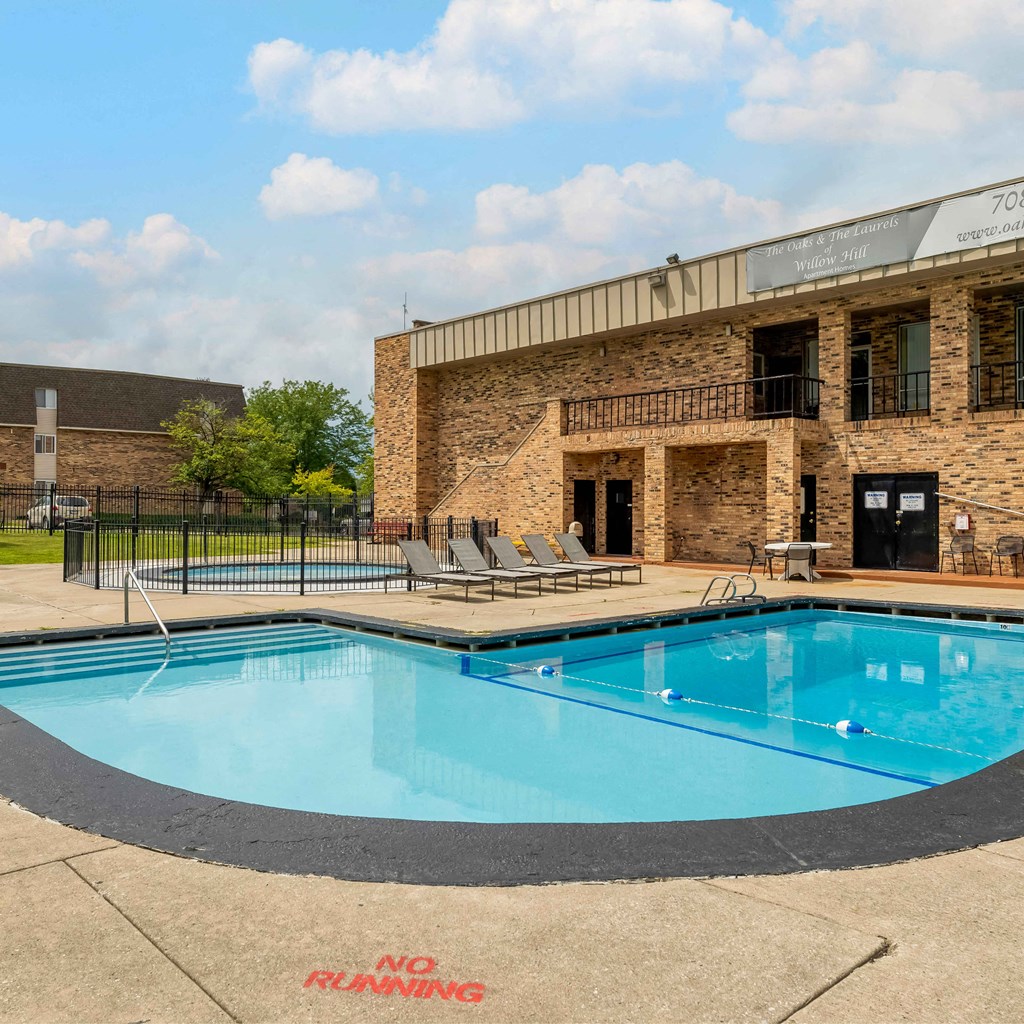 a swimming pool in front of a brick building with a pool