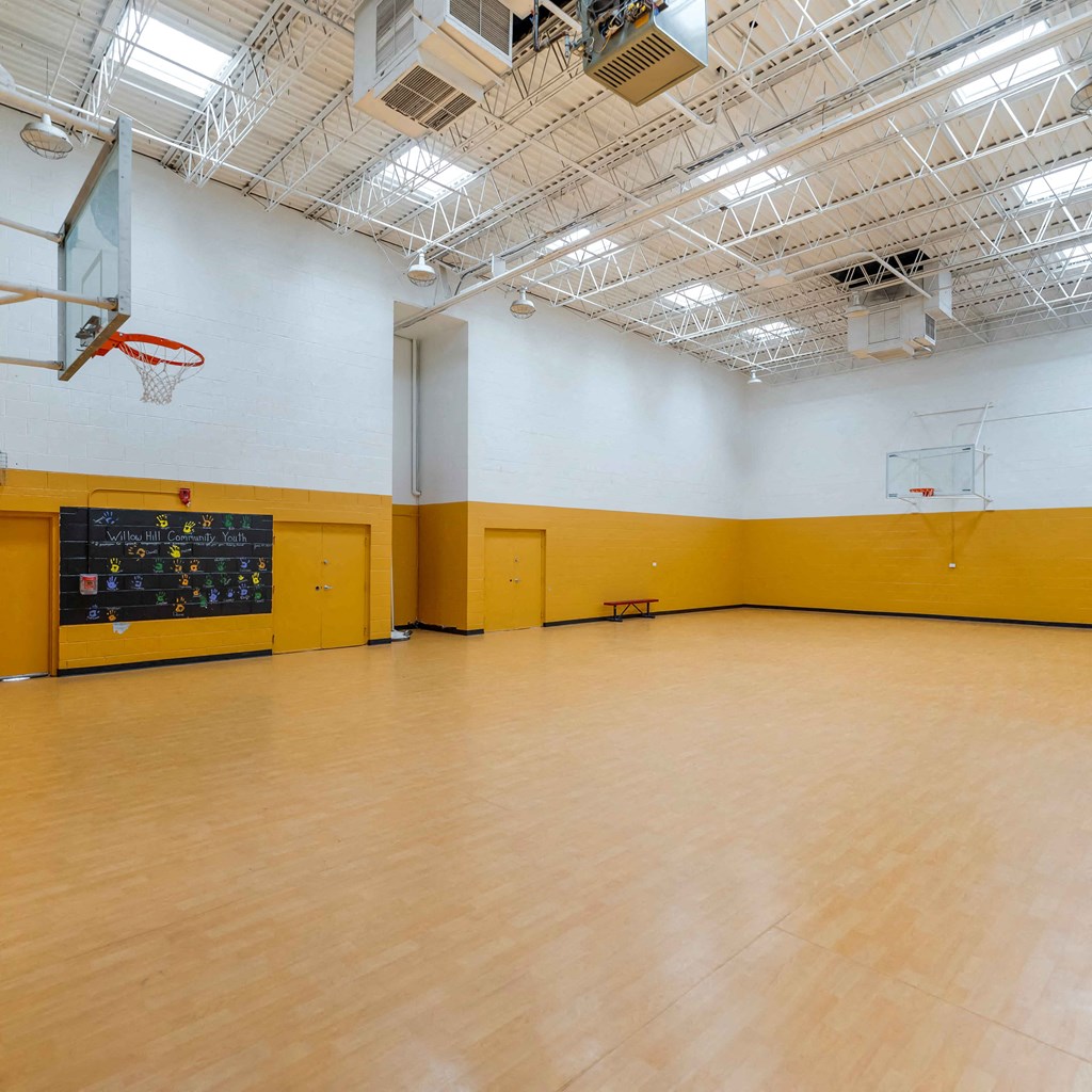 a large room with a wooden floor and a basketball hoop