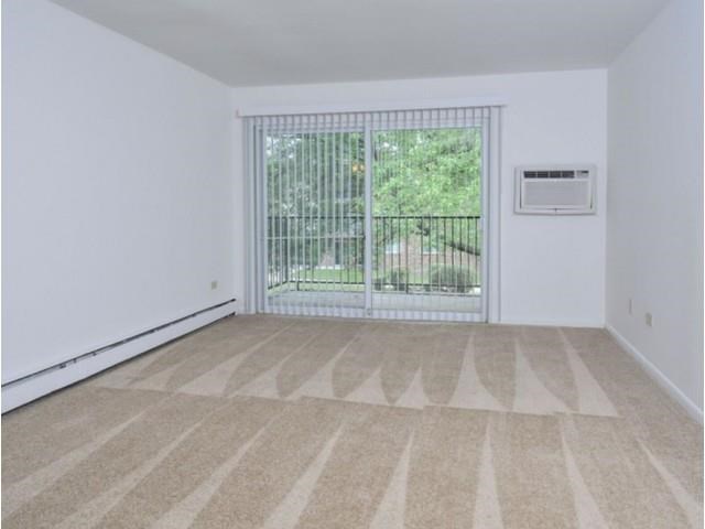 an empty living room with a door to a balcony
