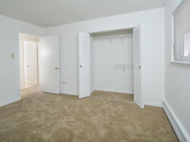 an empty bedroom with a closet and a window