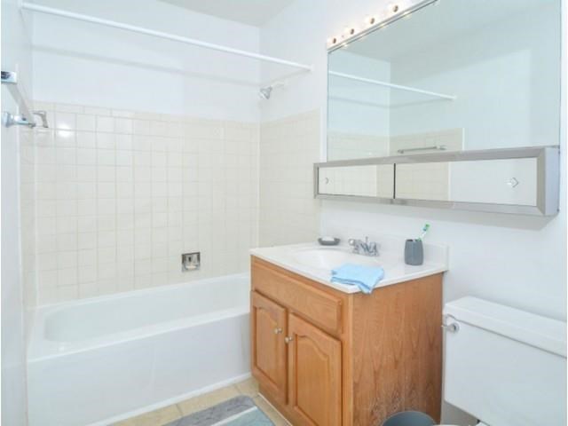 a bathroom with a white tub and a sink and a mirror