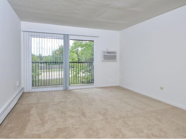 an empty living room with a window and a radiator