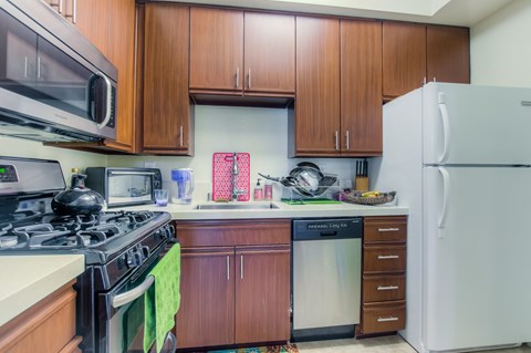 A kitchen with a stove, microwave, and refrigerator.