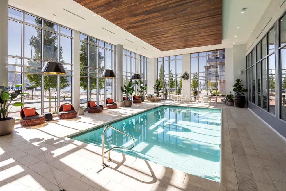 a swimming pool in a room with floor to ceiling windows