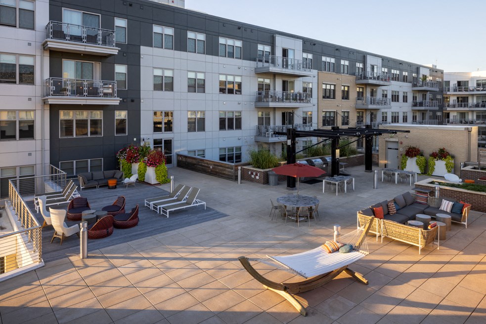 a rendering of an outdoor patio with lounge chairs and tables