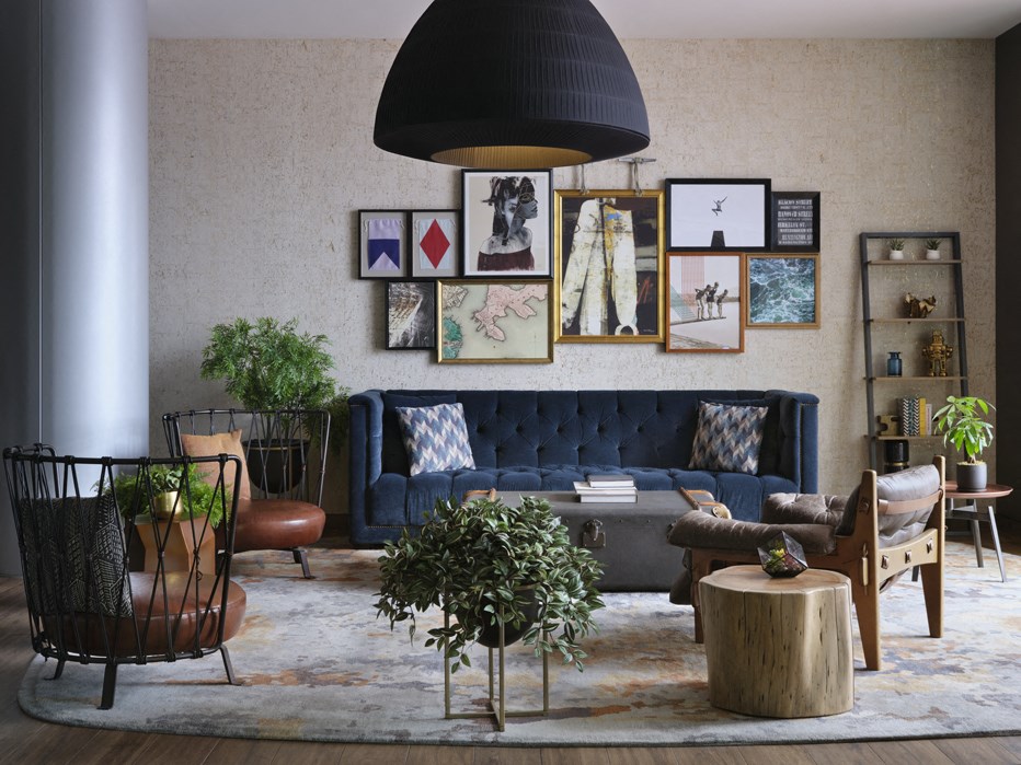 a living room with a blue couch and a gallery wall
