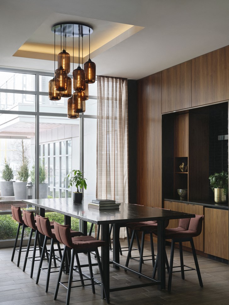 a dining room with a black table and chairs and a large window