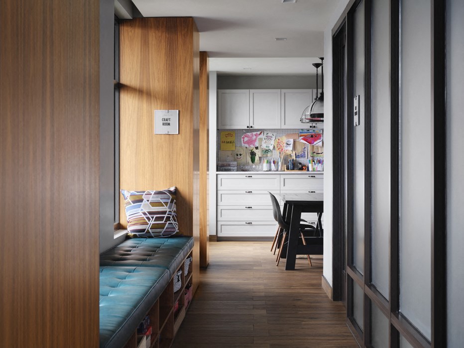 a small living room with a bench and a kitchen in the background