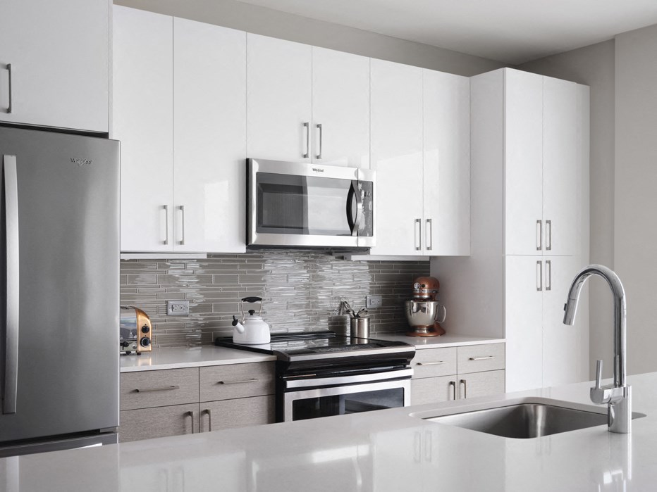 a kitchen with white cabinets and a sink and a microwave