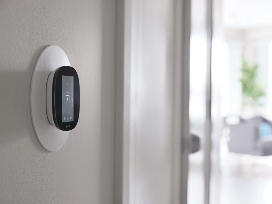 an open door with a thermostat on the wall