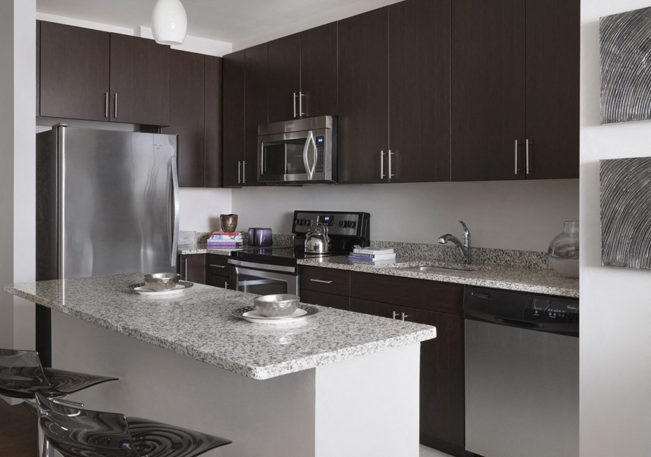 a kitchen with a granite counter top and a stainless steel refrigerator