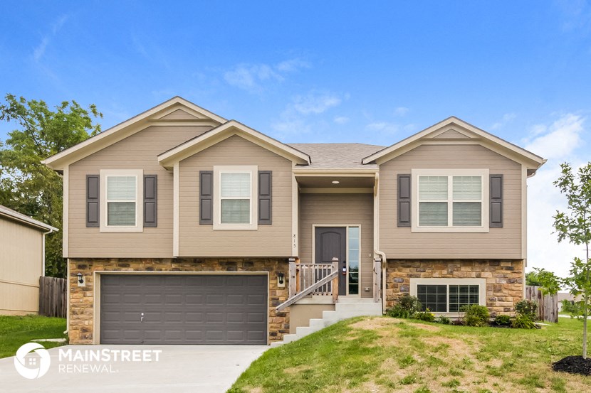 a beige and brown house with a garage door